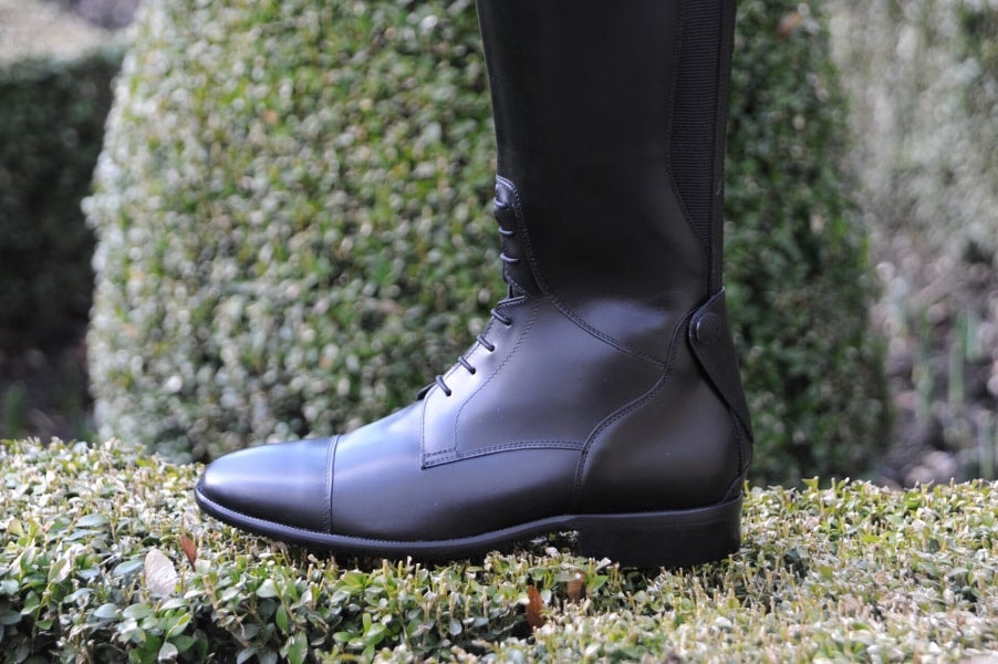 Dardant black leather lace-up boot on moss-covered stone wall